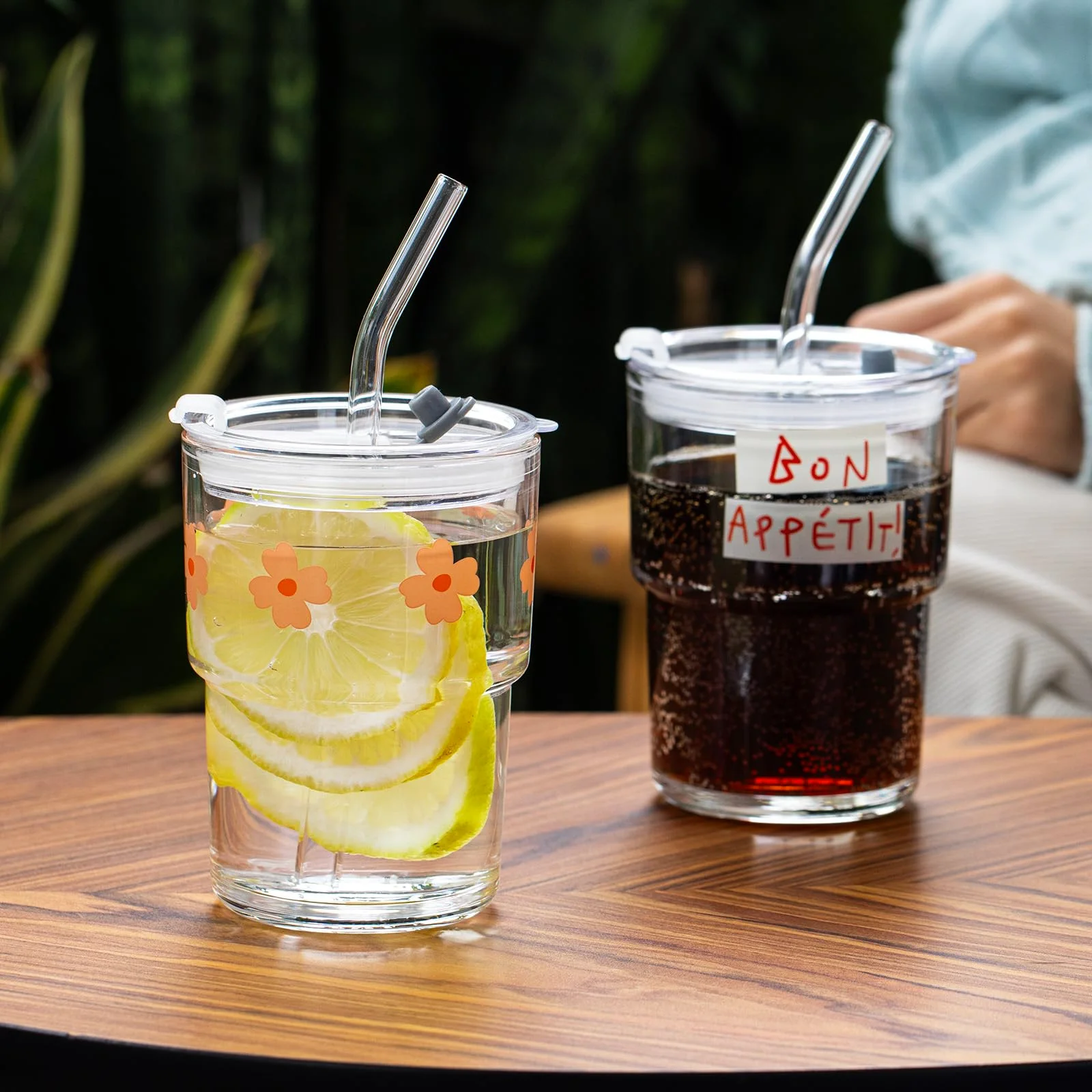 Two Bon Appétit glasses on a table, one with juice and one with cola.